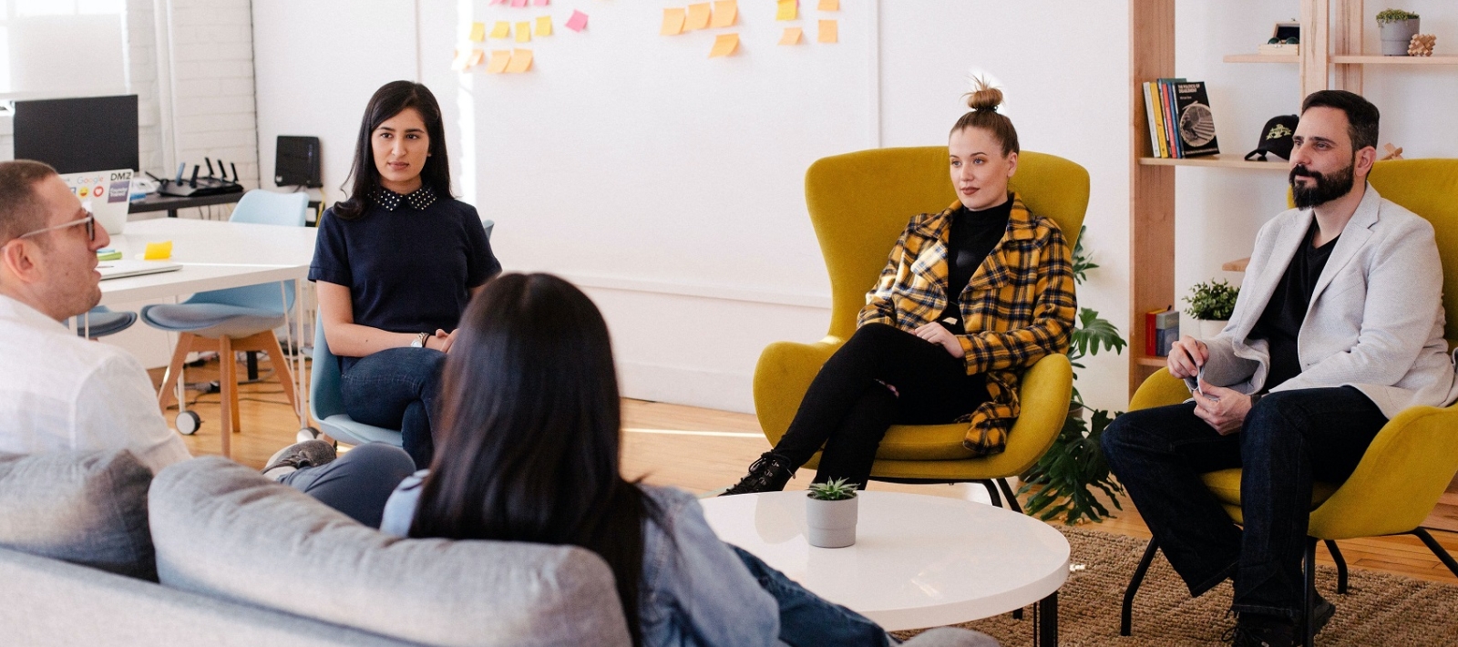 Group of men and women talking around coffee table